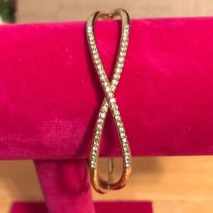 Crisscross bracelet, gold tone with rhinestones on two sides.
